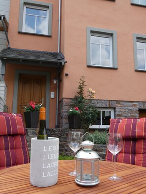 Enjoy a romantic dinner for two in this serene outdoor seating area, complete with a table set and a beautiful lantern.