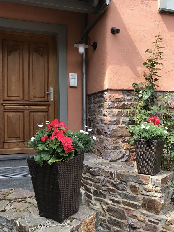 Two potted plants adorn the entrance, adding a touch of greenery to the building's exterior.