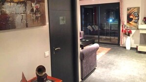 Ein modernes Wohnzimmer mit einer Schiebetür aus Glas zum Balkon, einem Sofa und einem Couchtisch.