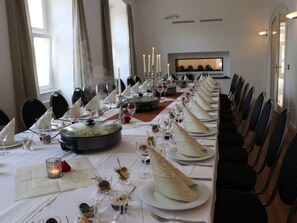 A long dining table set for a formal meal with multiple courses, candles, and a view of the room. - Schloss Hohendorf (Gross Mohrdorf)
