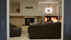 Una sala de estar moderna con chimenea, un sofá y una televisión.