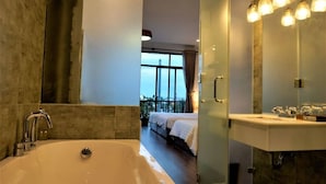 Une salle de bain moderne dotée d’une grande baignoire, d’une douche à l’italienne et d’un meuble-lavabo avec un miroir.