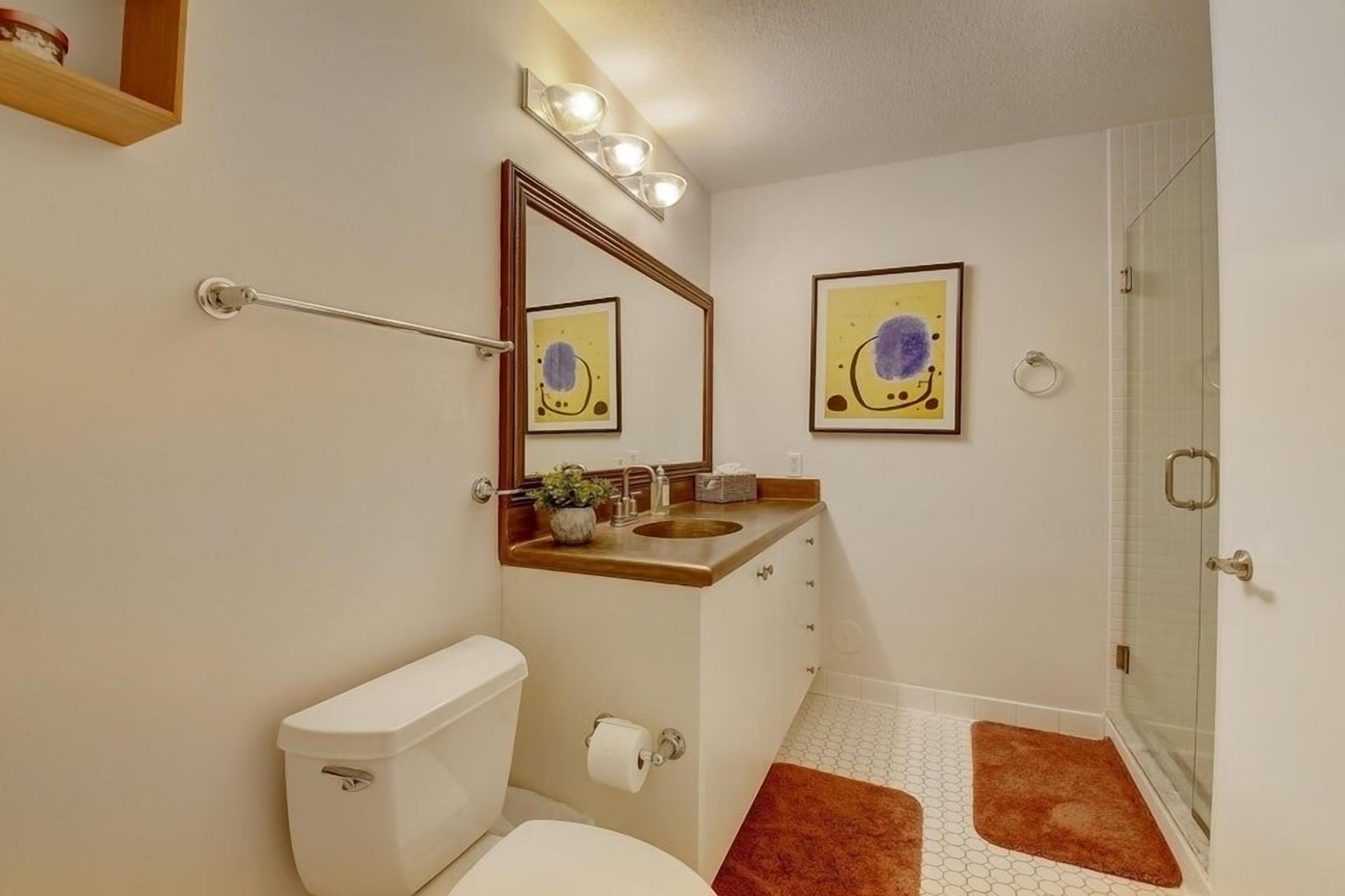 A bathroom with a toilet, sink, and shower.