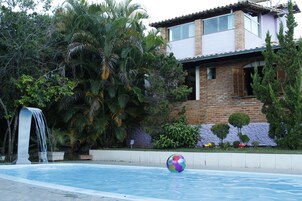Una piscina al aire libre, sillones reclinables de piscina