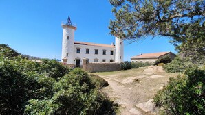 A white building with a tower and a smaller building with a red roof.