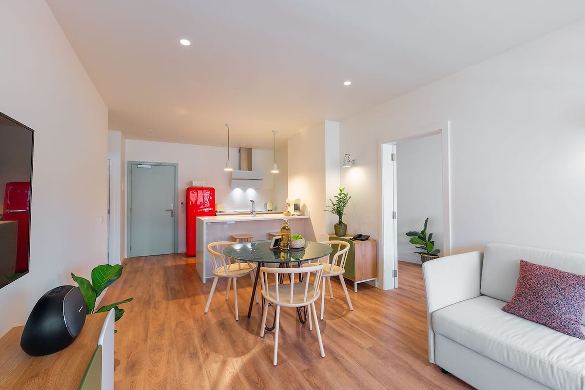 A modern apartment with a dining area, kitchen, and living room.