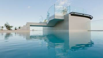 Alberca al aire libre, sombrillas en la alberca y camastros