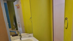 Et badeværelse med vask, spejl og toilet.