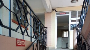 Zona de recepción con una escalera que lleva a un espacio interior.