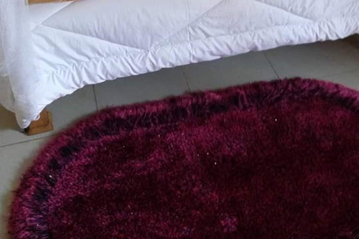 Un lit à baldaquin, avec une literie blanche et un couvre-lit à motifs.