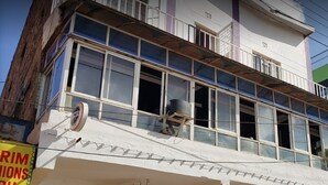 A multi-story building with a balcony, a sign for 'Royal Prince', and a sign for 'Rimions'. - Royal Prince 2 Hotel (Meru)