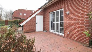 A brick house with a white door and large windows.