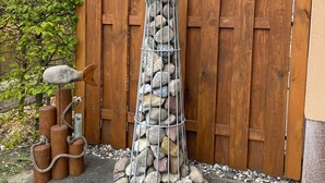 Una valla de madera con una estructura metálica de farol llena de piedras.
