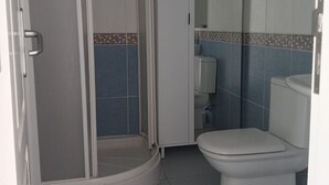 A bathroom with a shower enclosure, toilet, and a mirror. - Studio Playa Mogan Hungarian (Mogan)