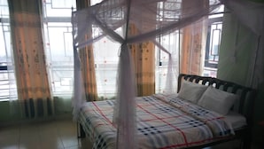 Une chambre à coucher avec un lit, des rideaux et une fenêtre.