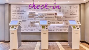 Ein Check-in-Terminal in einem Hotel mit einer Wand voller motivierender Zitate im Hintergrund.