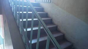 A staircase with metal railings leading to an upper floor. - Sunset Guest House (Meru)