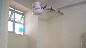 A bathroom with a window, a water heater, and patterned tiles. - Sunset Guest House (Meru)
