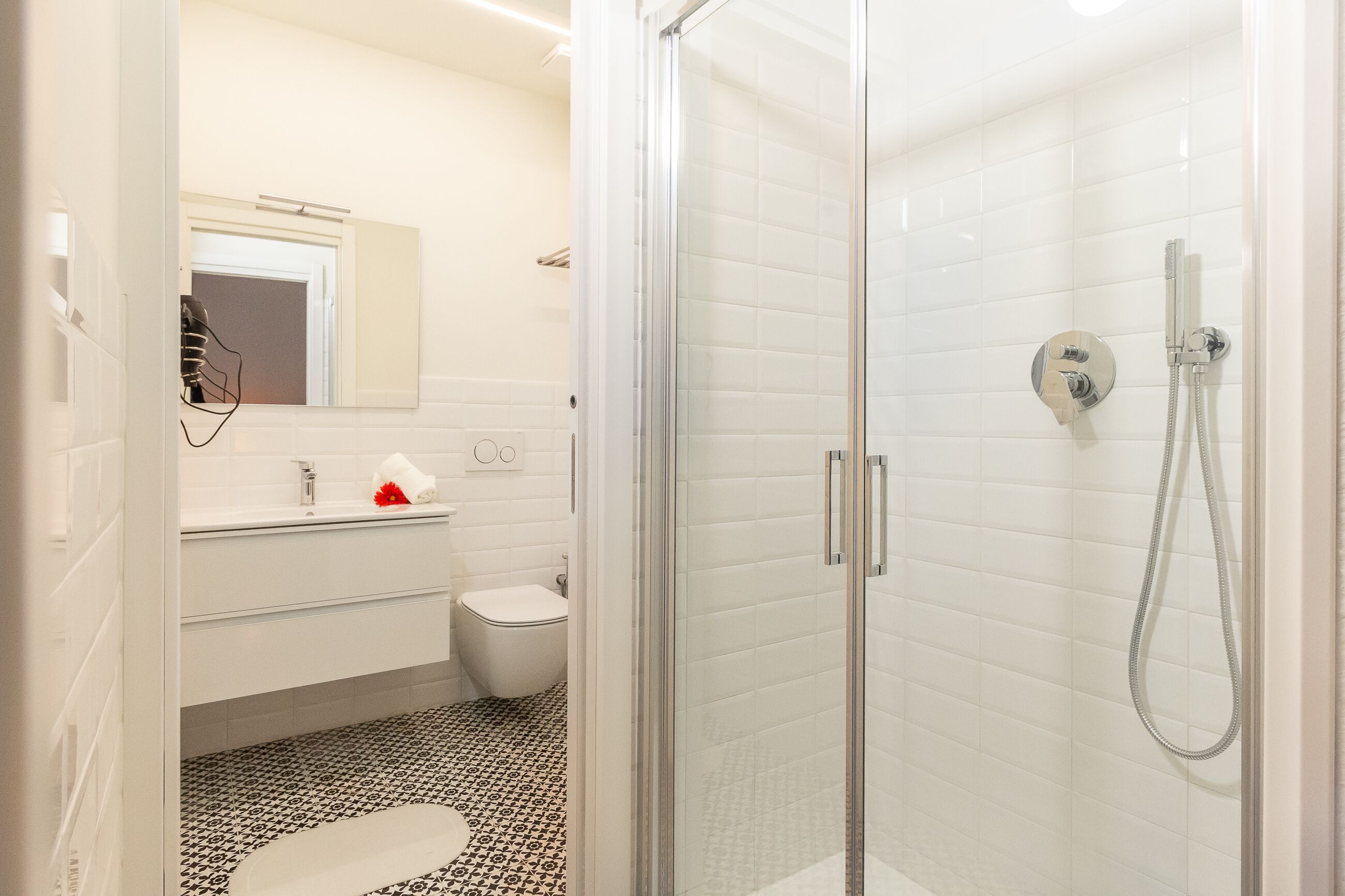 Un bagno moderno con doccia vetrata, lavandino bianco e water.