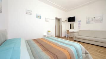 Um quarto com cama, escrivaninha, sofá e obras de arte nas paredes.