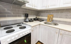 Stort kylskåp, mikrovågsugn, spishäll och grytor/köksredskap