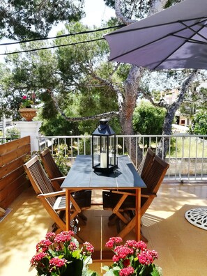 A wooden table with chairs, a lantern, and potted flowers on an outdoor patio. - House 2 Pins, House 300m From the Beach of Porto Cristo (Manacor)