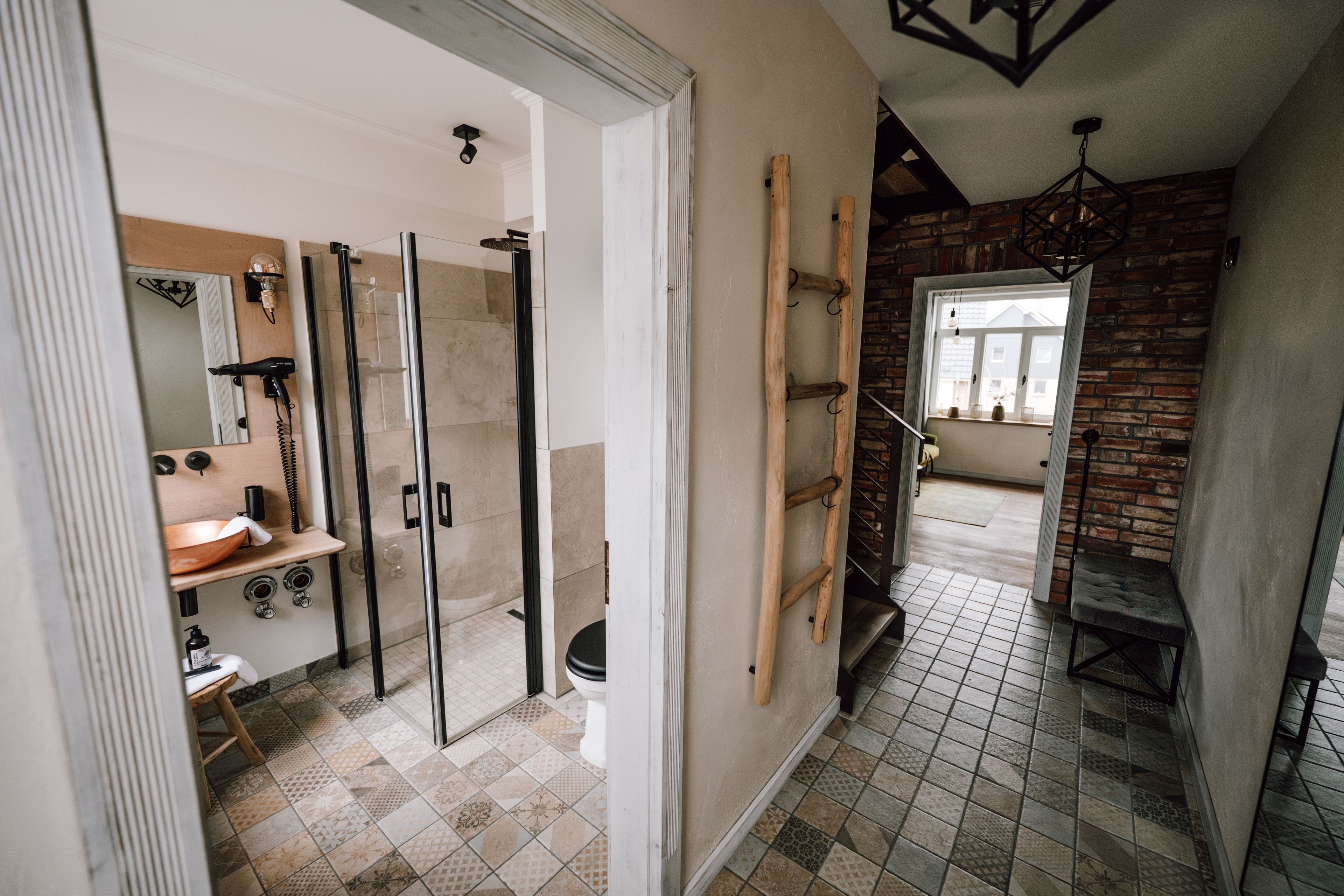 Ein modernes Badezimmer mit Duschkabine aus Glas, einem Holzboden und einer sichtbaren Toilette.