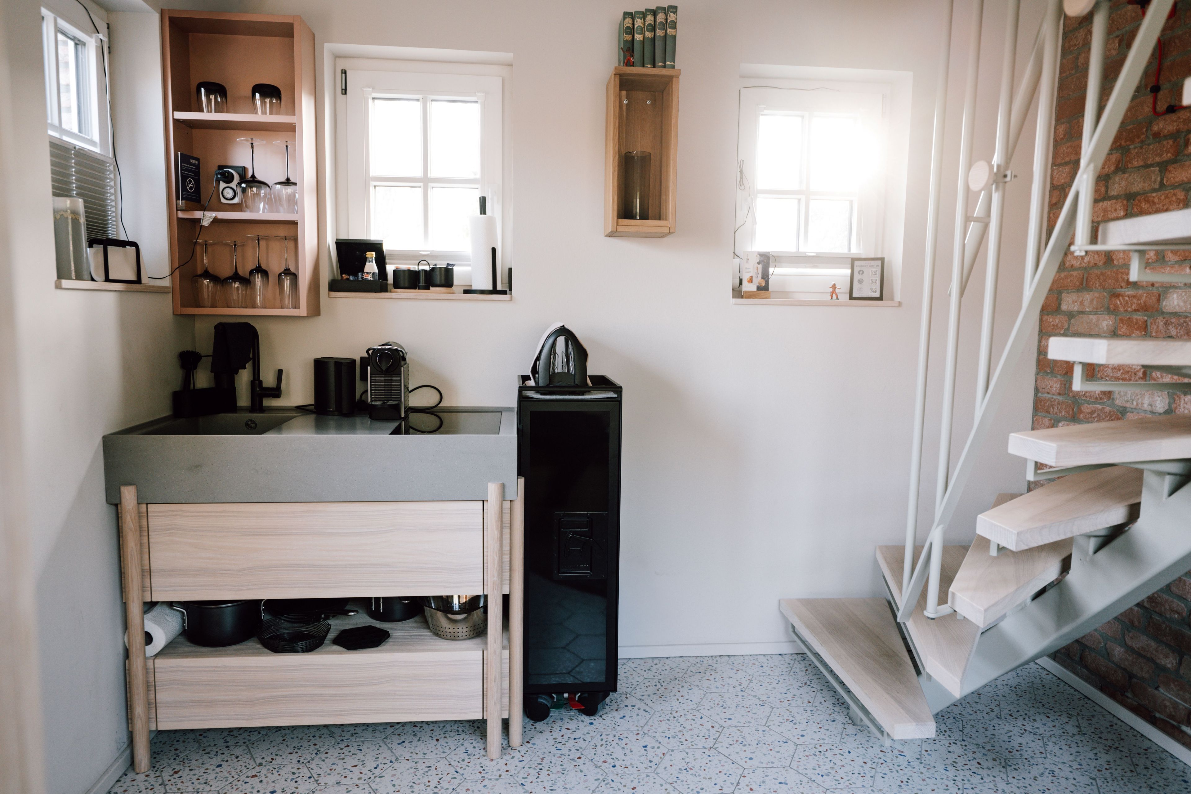 A compact kitchen with a built-in oven, a coffee machine, and a small sink.
