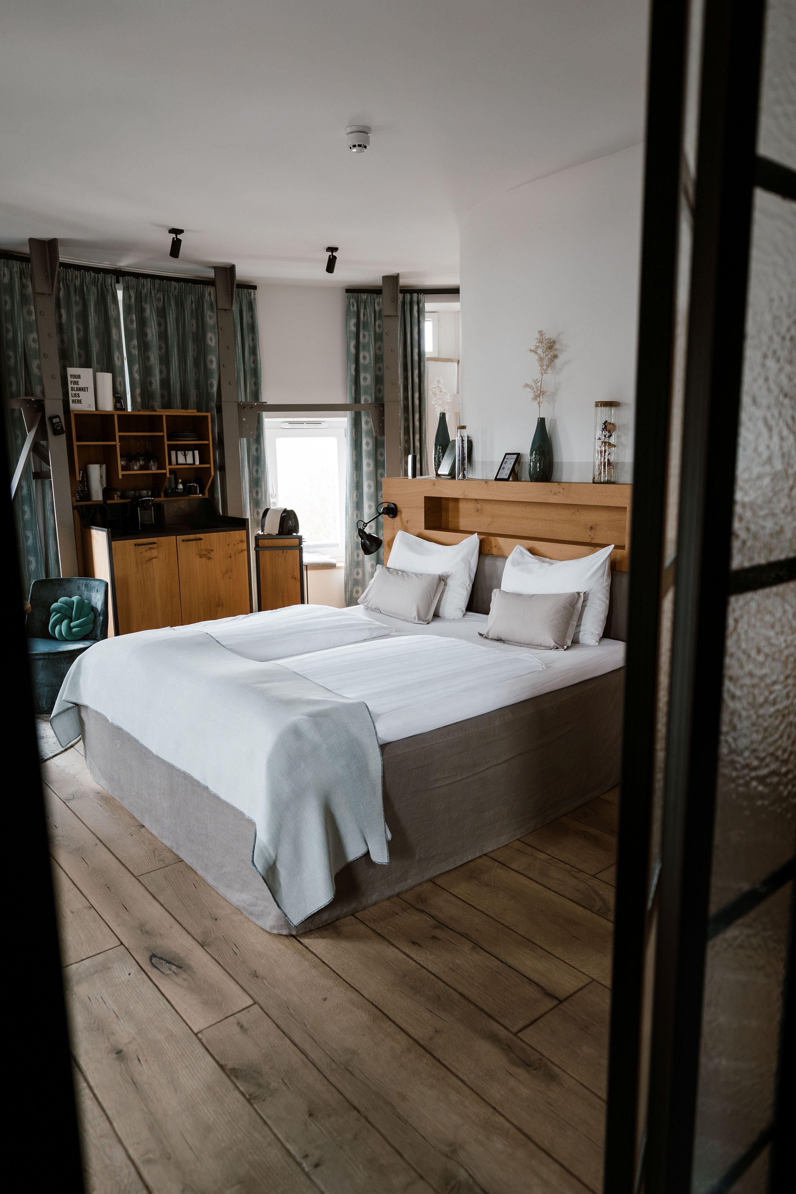 Ein Schlafzimmer mit einem großen Bett, einem Holzkopfstück, Nachttischlampen und einem Nachttisch.