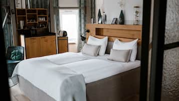 Ein Schlafzimmer mit einem großen Bett, einem Holzkopfstück, Nachttischlampen und einem Nachttisch.
