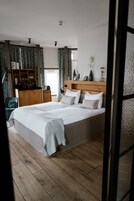 Un dormitorio con una cama grande, cabecera de madera, lámparas de noche y una mesita de noche.