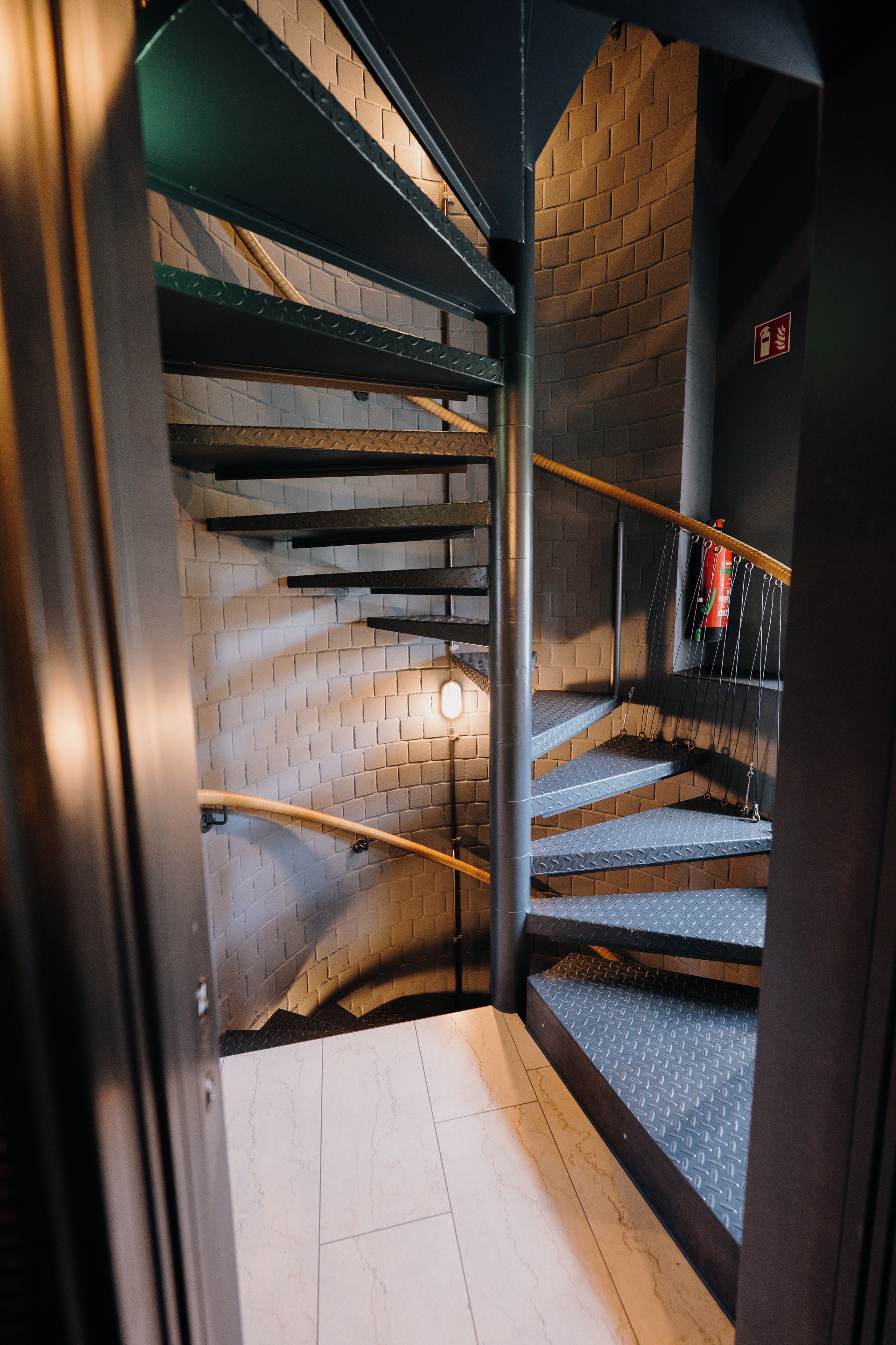 A staircase with metal railings and a brick wall.