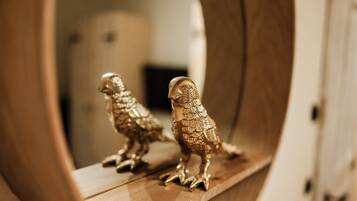 A wooden shelf with two golden owl figurines.