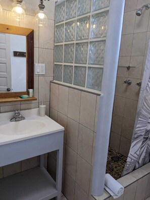 Suíte estúdio design | Banheiro | Chuveiro, toalhas de banho, sabonete, shampoo