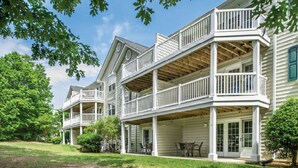 A two-story house with a covered porch and a balcony.