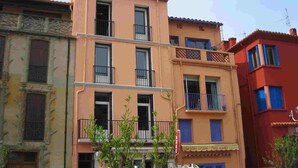 Edifício com várias andares, varandas e placa indicando um restaurante.