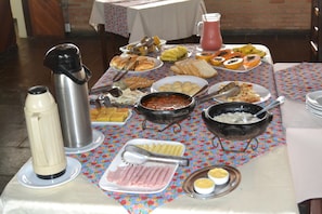 Un tavolo per buffet con diversi cibi, tra cui pane, frutta e una pentola calda.