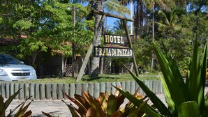A sign for Hotel Praia da Paixao with a white car parked in front. - Hotel Praia da Paixão (Prado)