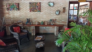 A cozy interior with wicker furniture, a brick wall, and a 'RESTAURANT' sign. - Hotel Praia da Paixão (Prado)
