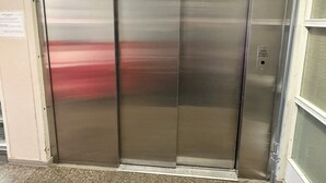 A metallic elevator with a control panel on the right side. - Kurimon majatalo (Suomussalmi)