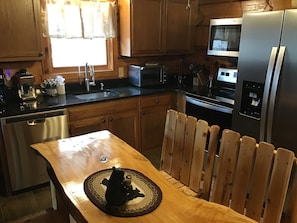 A kitchen with wooden cabinets, a stainless steel refrigerator, a microwave, and a dishwasher. - Close to Dollywood & All Attractions! Newly Renovated Dancing Bear 4 (Sevierville)