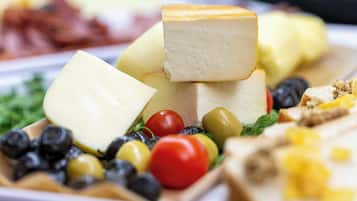 A variety of cheeses and fruits on a plate.