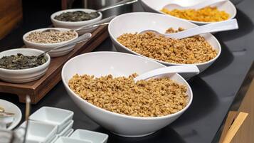 Una mesa de buffet con diferentes alimentos en recipientes.