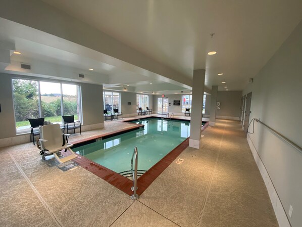 A swimming pool with a tiled deck, chairs, and a view of the outdoors. - Candlewood Suites Lebanon by IHG (Lebanon)