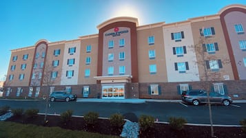 A multi-story hotel with a prominent entrance and a parking lot in front.