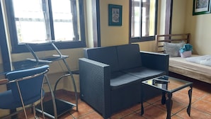 Une pièce comprenant un canapé, une petite table, une chaise et un lit.