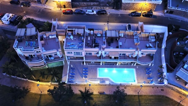 Un hôtel à plusieurs étages doté d’une piscine, de nombreux balcons et d’un espace de stationnement.