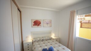 Une chambre à coucher avec un lit, des tables de chevet et une fenêtre avec des rideaux.