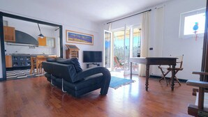 Een appartement met twee slaapkamers, een woonkamer, een eethoek en een keuken. Het heeft een groot raam en uitzicht op zee.