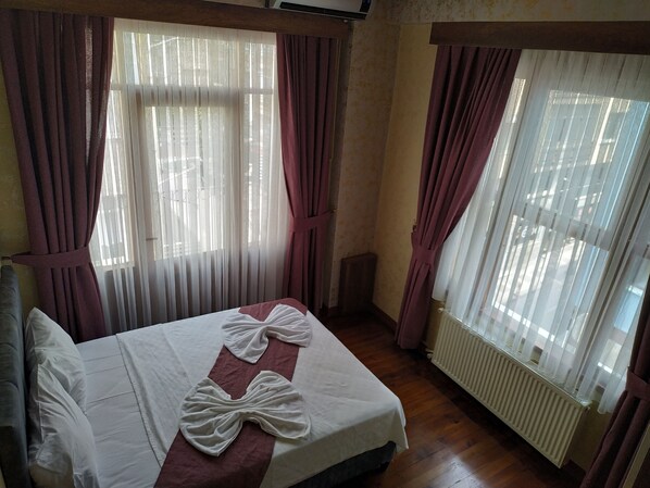 A hotel room with a bed, curtains, and a window. - Lorin Otel (Istanbul)